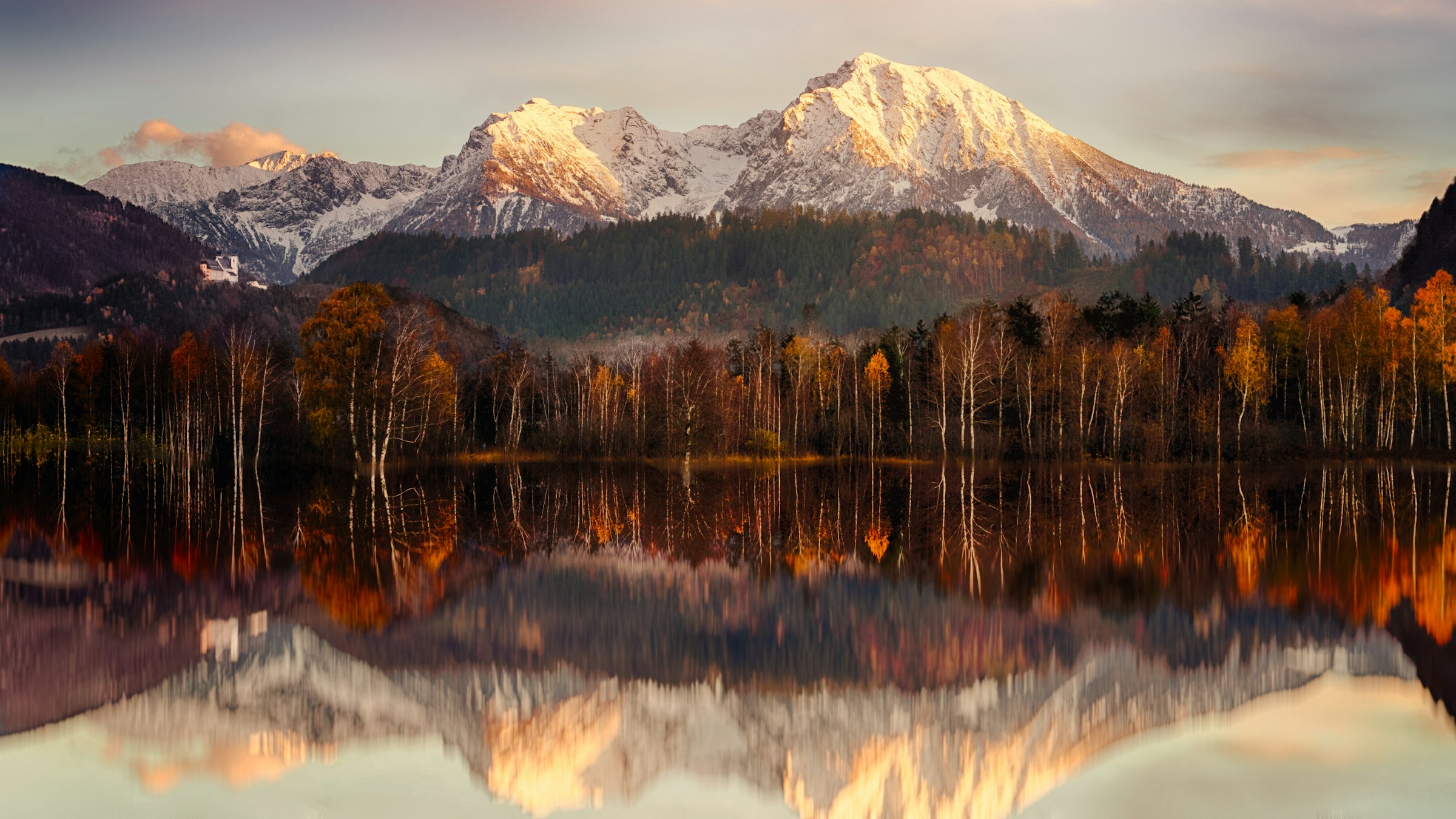 A mountain range mirrored in a still lake